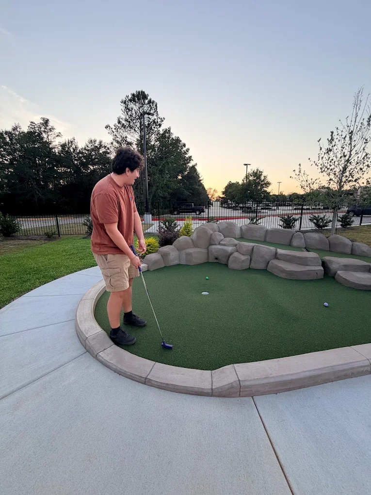 Player putting at sunset on the Party Mini Golf course